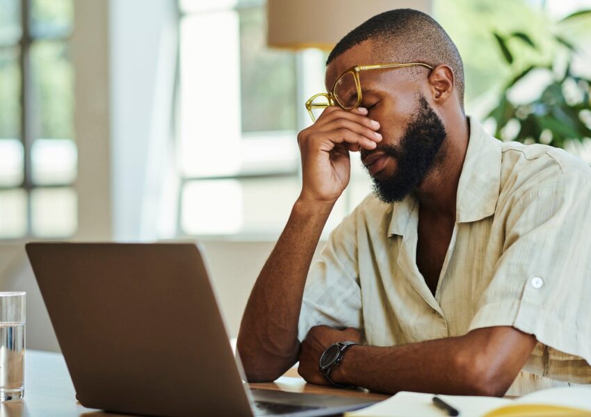 Young African man with laptop working indoors, home office concept. stock photo
